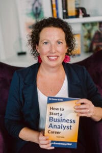 Laura Brandenburg holding her book How to Start a Business Analyst Career